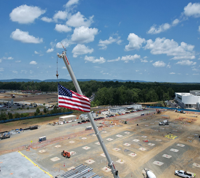 image of an American flag flying from a crane over a construction site